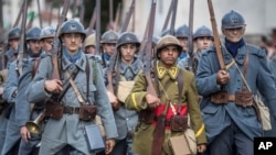 Men dressed in WWI uniforms march during a parade, part of a reconstruction of the WWI battle of Verdun, Aug. 25, 2018, in Verdun, eastern France. 