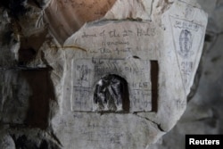 Inscriptions by WWI Private David McAlpine, 2nd Highland Light Infantry, are seen on the rock wall in underground caves accessible by small spiral stairs in the village's church at Bouzincourt, northern France, July 13, 2015.