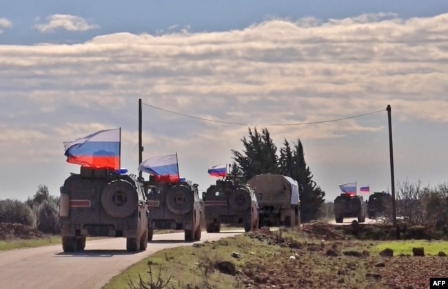 An image grab taken from AFP-TV on Jan. 17, 2019, shows Russian army vehicles on patrol in the area of Arimah, just west of Manbij, Syria, where a day earlier a suicide attack on a restaurant killed four U.S personnel.