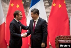 French President Emmanuel Macron, left, and Chinese President Xi Jinping shake hands after a joint press briefing at the Great Hall of the People in Beijing, China January 9, 2018. REUTERS/Mark Schiefelbei/Pool