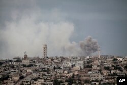 FILE - Smoke rises after a TNT bomb was thrown from a helicopter, hitting a rebel position during heavy fighting between troops loyal to Syrian President Bashar al-Assad and opposition fighters, near Kafr Nabuda, Idlib province, Syria, Sept. 19, 2013.
