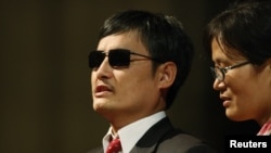 FILE - Blind Chinese activist Chen Guangcheng (l), accompanied by his wife Yuan Weijing.