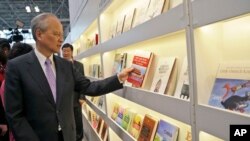 Cui Tiankai, Ambassador of China to the United States, inspects a book as he tours the China pavilion at BookExpo America, May 27, 2015, in New York.
