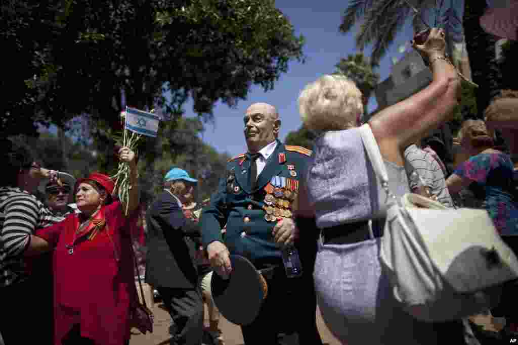 Russian-Israeli World War II veterans dance during a street parade marking Victory Day in Haifa, Israel. Israeli veterans from the former Soviet Union marched together with their families to celebrate the 68th anniversary of the Allies victory over Nazi Germany in 1945. 