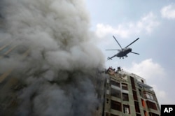 A chopper hovers to evacuate people stuck in a multi-storied office building that caught fire in Dhaka, Bangladesh, March 28, 2019.