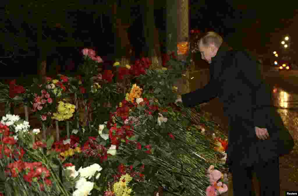 Russian President Vladimir Putin lays flowers at the site of a trolley bus explosion, Volgograd, Russia, Jan. 1, 2014. 