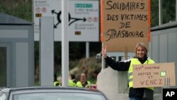 Un manifestante sostiene una pancarta que dice "Todos juntos, pónganse sus chalecos amarillos y vengan", en Biarritz, suroeste de Francia.