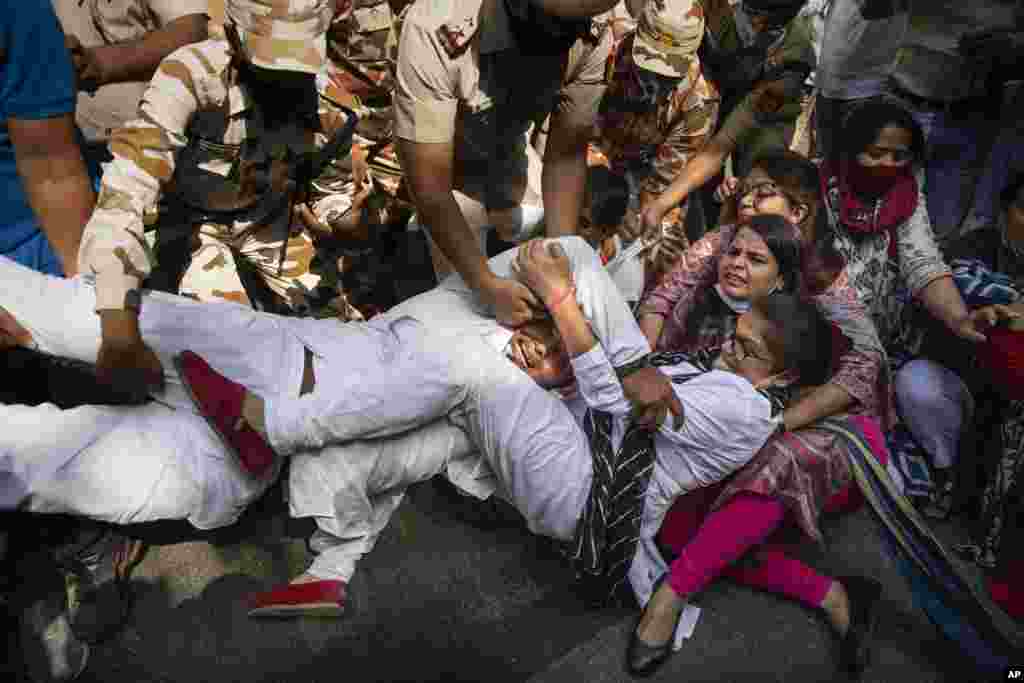 India's opposition Congress party supporters protesting against gang rape and killing of a woman in Uttar Pradesh’s Hathras district hold onto each other as Indian policemen try to detain them in New Delhi, India, Wednesday, Sept. 30, 2020 (AP)