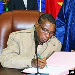 Guinean junta chief Captain Camara signs pact on 15 Jan 2010 in Ouagadougou during a meeting with interim junta chief General Sekouba Konate and Burkina Faso President Blaise Compaore