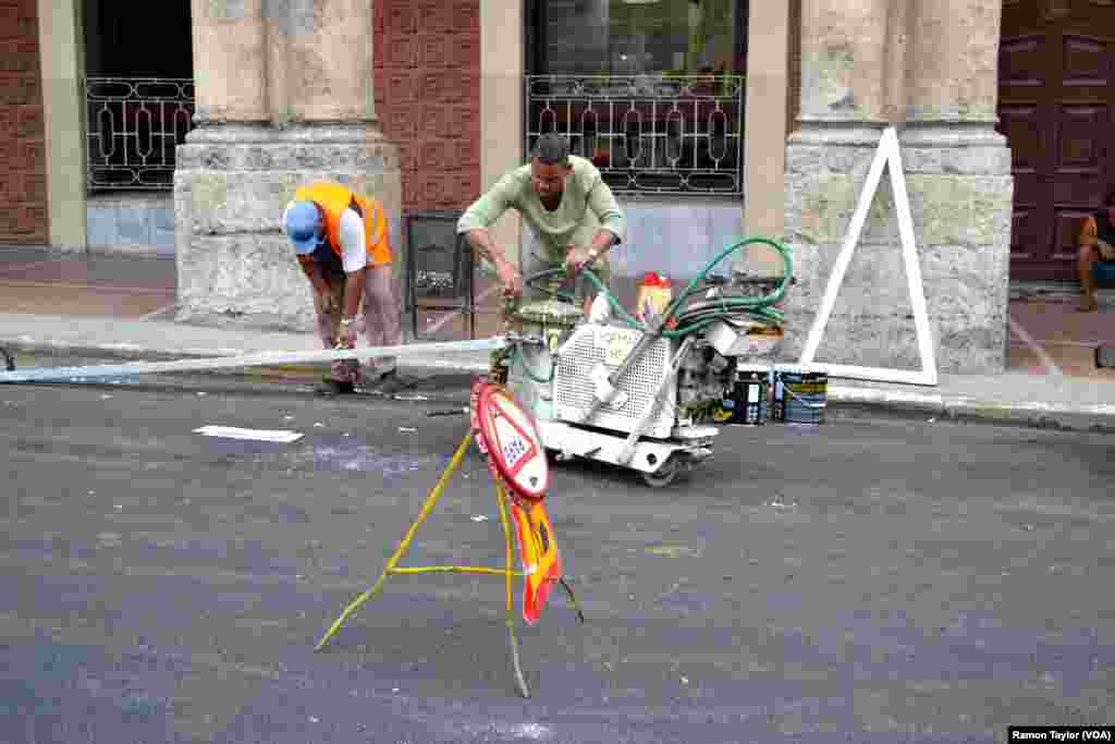 Workers make repairs on a road in Havana.