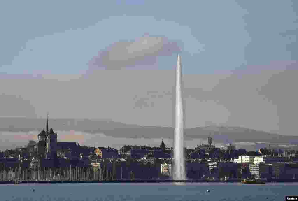 The Water fountain (Jet d&#39;eau) is seen in front the Saint-Pierre Cathedral in Geneva, Switzerland.