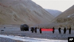 Quân đội Trung Quốc cầm biểu ngữ với hàng chữ: "Bạn đã vượt qua biên giới, xin vui lòng quay trở lại" tại Ladakh, Ấn Độ, ngày 5/5/2013.