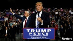 Republican U.S. presidential nominee Donald Trump (R) and vice presidential candidate Mike Pence (L) hold a campaign rally in Cleveland, Oct. 22, 2016.