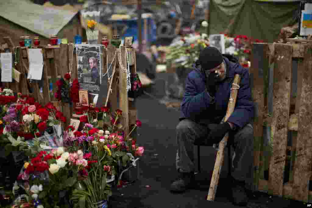An anti-Yanukovych protester cries near a memorial for the people killed in clashes in Kyiv's Independence Square, Feb. 25, 2014.