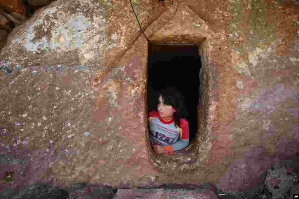 Nihal, 9, sığınacaq kimi istifadə olunan qədim yeraltı Roma məqbərəsinin girişinə baxır. Cabal əl-Zaueya, İdlib vilayəti, Suriya. 28 fevral, 2013.