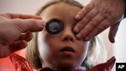FILE - A girl's eyes are examined March 8, 2012.