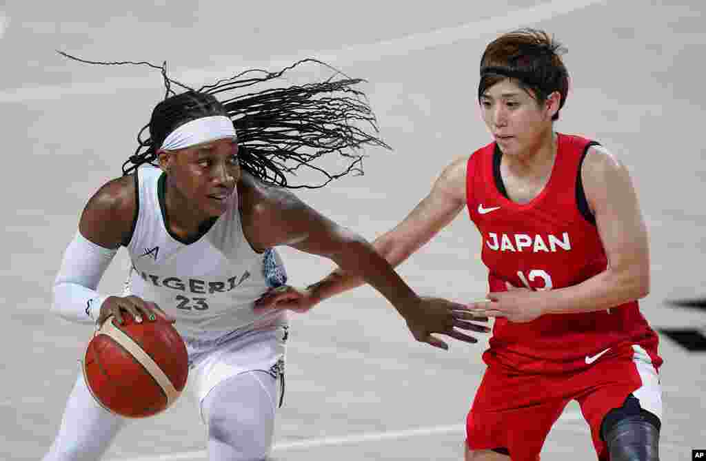 Nigeria&#39;s Ezinne Kalu (23) drives past Japan&#39;s Rui Machida (13), right, during women&#39;s basketball preliminary round game at the 2020 Summer Olympics, Monday, Aug. 2, 2021, in Saitama, Japan. (AP Photo/Charlie Neibergall)