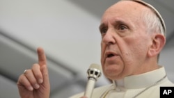 Pope Francis answers reporters questions during a news conference aboard the papal flight on the journey back from Brazil, July 29, 2013. 