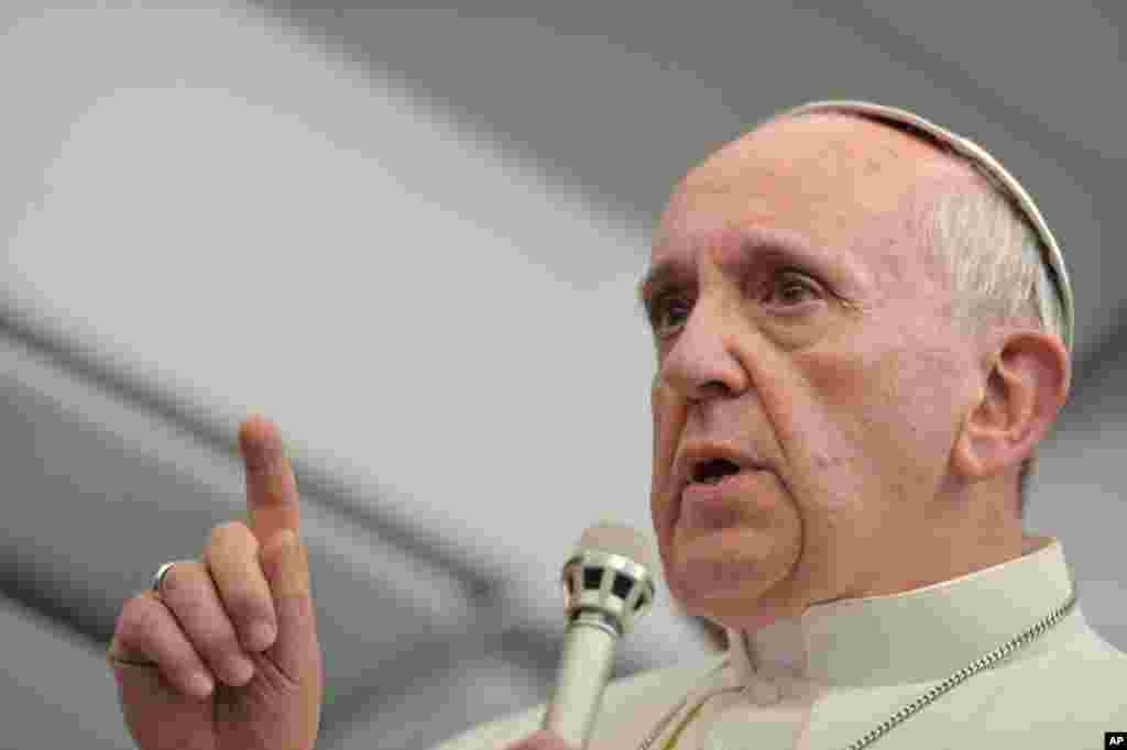 Pope Francis answers reporters questions during a news conference aboard the papal flight on the journey back from Brazil, July 29, 2013.