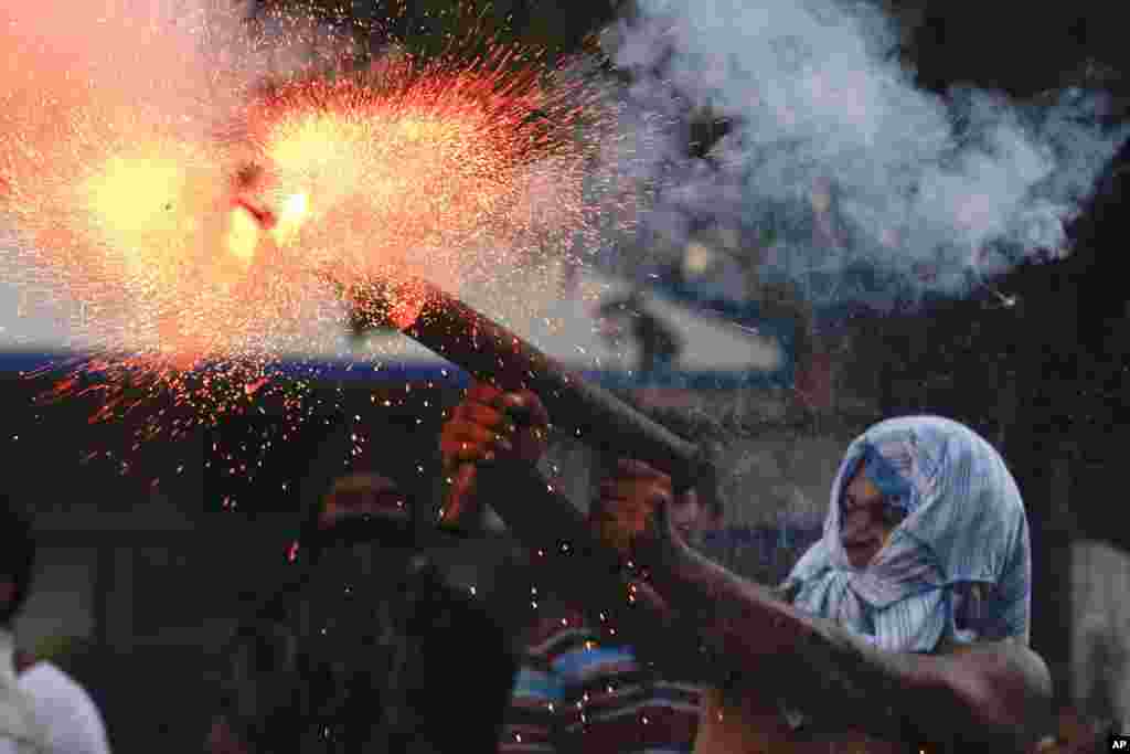 A relative of the former worker of the Ingenio San Antonio fires a homemade mortar during protests in Chichigalpa, Nicaragua, Jan. 19, 2014. The former sugarcane cutters were demanding compensation for damages to their health resulting from alleged exposure to agrochemicals and pesticides when the protest turned violent.