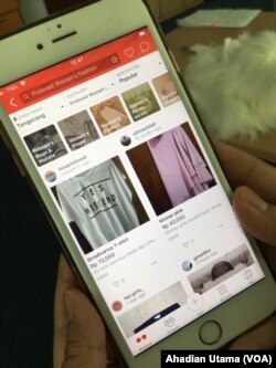 Seorang konsumen sedang melihat-lihat barang bekas bermerek atau preloved branded items di aplikasi Carousell, Jakarta, 23 Mei 2018. (Foto: VOA/Ahadian Utama)