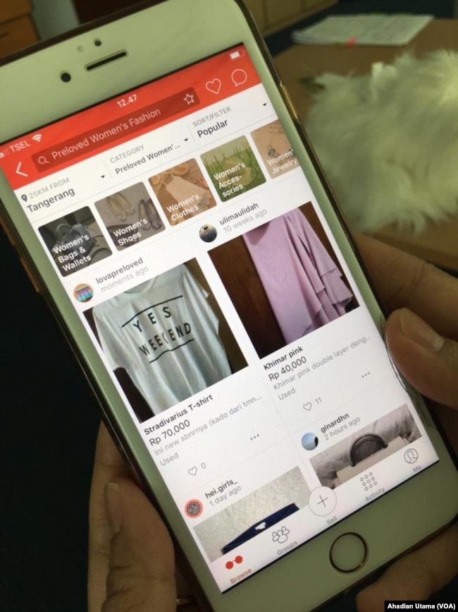 Seorang konsumen sedang melihat-lihat barang bekas bermerek atau preloved branded items di aplikasi Carousell, Jakarta, 23 Mei 2018. (Foto: VOA/Ahadian Utama)