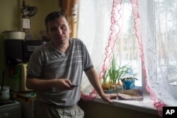 Yevgeny Berdyshev, half-brother of Alexander Potapov who is believed to be fighting in Syria, stands at the window at his home in the village of Kedrovoye, Russia, Feb. 15, 2018.