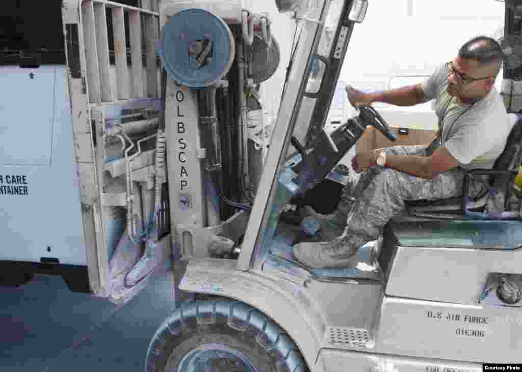 U.S. Air Force Tech. Sgt. Gautambhai Patel operates a forklift to get pallets consisting of food and water to displaced citizens near Sinjar, Iraq, Aug. 11, 2014. (U.S. Department of Defense)