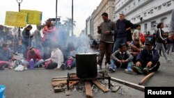 People wait to receive a free meal at a soup kitchen set up on 9 de Julio avenue during a demonstration against the government’s economic measures in Buenos Aires, Argentina Sept. 12, 2018.