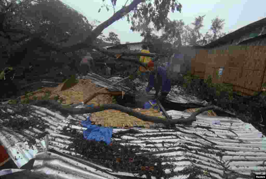 Residents retrieve their belongings after their house was destroyed by a fallen tree caused by Typhoon Bopha in Cagayan de Oro City, Philippines, December 4, 2012.