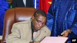 Guinean junta chief Captain Camara signs pact on 15 Jan 2010 in Ouagadougou during a meeting with interim junta chief General Sekouba Konate and Burkina Faso President Blaise Compaore