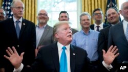 President Donald Trump, accompanied by Rep. Mike Conaway, R-Texas, left, Agriculture Secretary Sonny Perdue, right, and farmers and ranchers, speaks in the Oval Office of the White House, May 23, 2019, in Washington. 