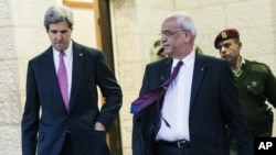 FILE - U.S. Secretary of State John Kerry, center, and Palestinian negotiator Saeb Erekat, right, leave the presidential compound after meeting with Palestinian President Mahmoud Abbas in the West Bank city of Ramallah on Saturday, Jan. 4, 2014.