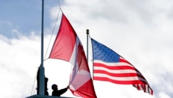 Washington state workers put up a new Canadian flag in front of an American flag during scheduled maintenance in Peace Arch Historical State Park, Nov. 8, 2021, in Blaine, Wash. A Jan. 10, 2022, U.S. State Department advisory discourages travel to Canada "due to COVID-19.”