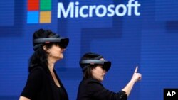 FILE- In this May 11, 2017, file photo, members of a design team at Cirque du Soleil demonstrate use of Microsoft's HoloLens device in helping to virtually design a set at the Microsoft Build 2017 developers conference in Seattle. Federal contract records