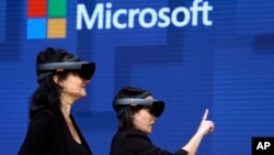 FILE: In this photo from the May 11, 2017 archive, members of a Cirque du Soleil design team demonstrate the use of Microsoft's HoloLens device to virtually help design a set at the developer conference of Microsoft Build 2017 in Seattle.  Federal contract records