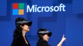 FILE- In this May 11, 2017, file photo, members of a design team at Cirque du Soleil demonstrate use of Microsoft's HoloLens device in helping to virtually design a set at the Microsoft Build 2017 developers conference in Seattle. Federal contract records