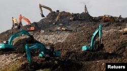 Heavy vehicles are seen at the Bantar Gebang landfill in Bekasi, West Java province, Indonesia, Aug. 12, 2021.