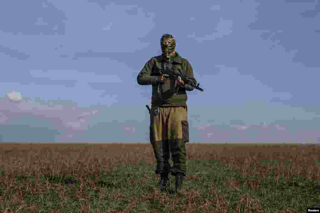 A pro-Russian rebel fighter who calls himself &quot;Hunter,&quot; purportedly an American from the state of Illinois, walks through a field near the town of Yasynuvata, in eastern Ukraine, Sept. 26, 2014. 