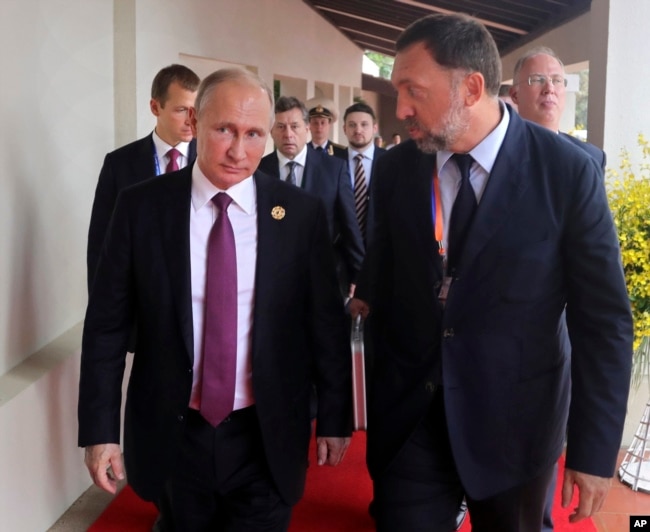 FILE - Russia's President Vladimir Putin (L) and Russian metals magnate Oleg Deripaska (R) walk to attend the APEC Business Advisory Council dialogue in Danang, Vietnam, Nov. 10, 2017.