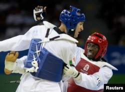 FILE - Mauro Sarmiento of Italy, in blue, and N'guessan Sebastien Konan of Ivory Coast fight during their men's preliminary round taekwondo match at the Beijing 2008 Olympic Games, Aug. 22, 2008.