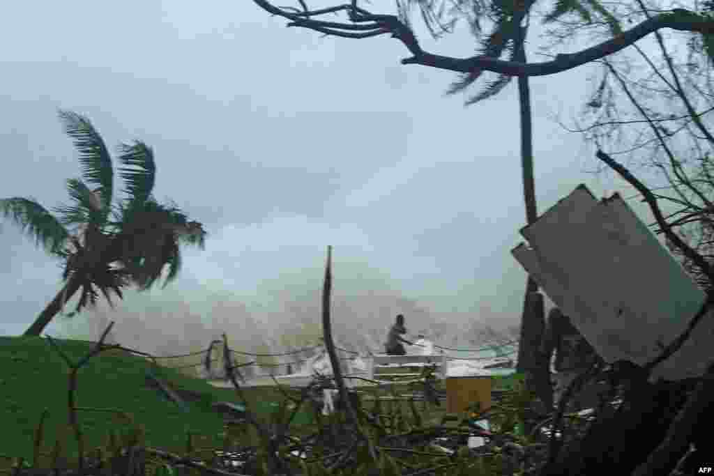 This handout photo received by CARE Australia shows a man running away from high waves caused by Cyclone Pam crashing along the coast in the Vanuatu capital of Port Vila, March 14, 2015. Cyclone-devastated Vanuatu declared a state of emergency as relief agencies scrambled to get help to the remote Pacific nation amid reports entire villages were &quot;blown away&quot; when the monster storm swept through.