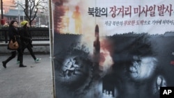 Spanduk memperlihatkan anak-anak Korut yang kelaparan dan peluncuran roket Korut terpampang di sebuah jalan di Seoul (foto: dok). Pejabat di Seoul dan Washington mengeluarkan peringatan serius atas uji coba nuklir Korut.