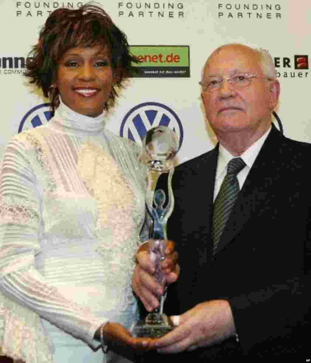 Former Soviet President Mikhail Gorbachev, right, and US singer Whitney Houston pose with her award prior the beginning of the World Women's Award ceremony in Hamburg's Congress Center, northern Germany, Wednesday, June 9, 2004. Whitney Houston will rece