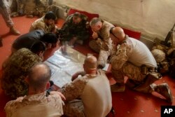 A photo released by Operation Resolute Support headquarters shows U.S. Marines with Task Force Southwest and Afghan National Army soldiers planning for the continuation of offensive combat operations at Camp Hanson, Afghanistan, June 13, 2017.