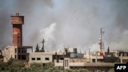 Smoke plumes rise from regime bombardment on the town of Al-Mulayhah al-Sharqiyah in the eastern Daraa province countryside in southern Syria, June 21, 2018.