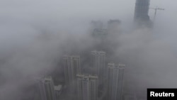 Buildings are seen shrouded in heavy haze at Qingdao development zone, Shandong province, Feb. 25, 2014. 
