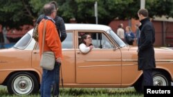 A Holden car fan sits in her car outside the Holden motor vehicle plant in Elizabeth, Australia, Oct. 20, 2017, as their last Commodore vehicle officially rolls off the production line Friday.