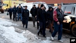 Employees are escorted from the scene of a shooting at a manufacturing plant, Feb. 15, 2019, in Aurora, Ill.