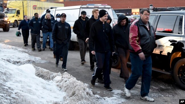 Employees are escorted from the scene of a shooting at a manufacturing plant, Feb. 15, 2019, in Aurora, Ill.